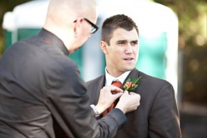 best man helping bridegroom with lapel flowers