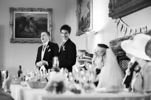 best man speech at wedding with bridegroom smiling and laughing