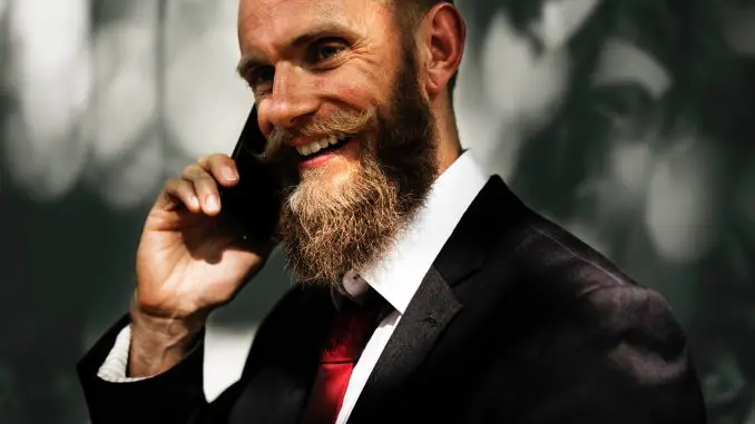 bearded man in suit and red tie