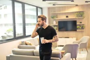man in black tshirt and jeans on a phone call