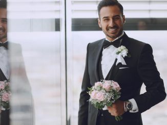 smiling groom holiding a bouquet